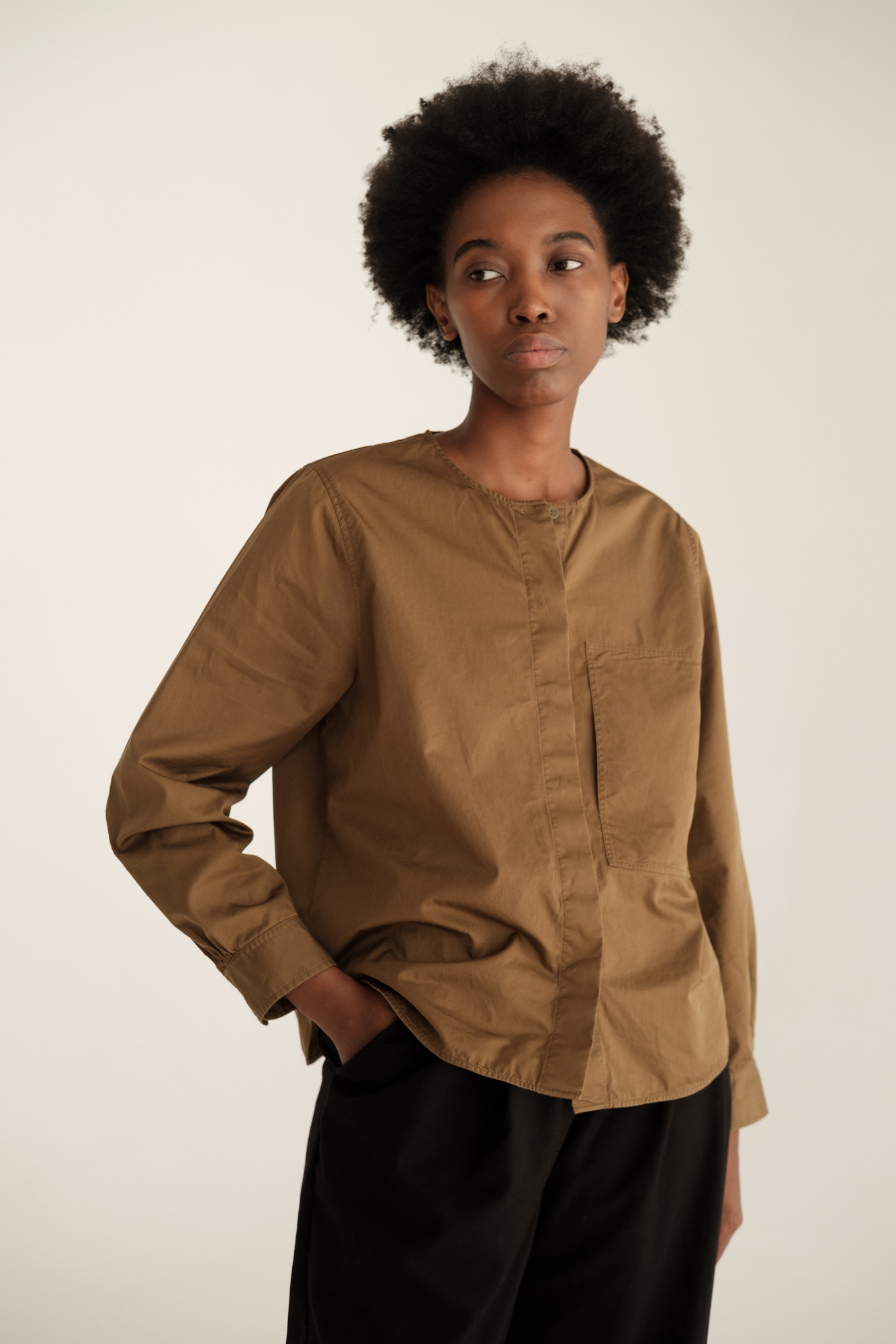 model wearing a brown shirt and black pants